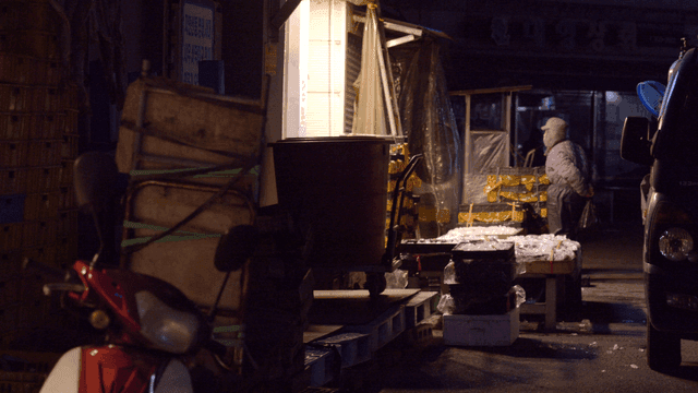 Dawn fish market with merchants and seafood displayed on ice