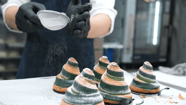 Pastry being dusted with powdered sugar
