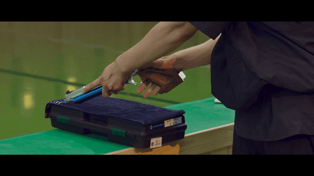 Shooting Sports: person who handles pistol