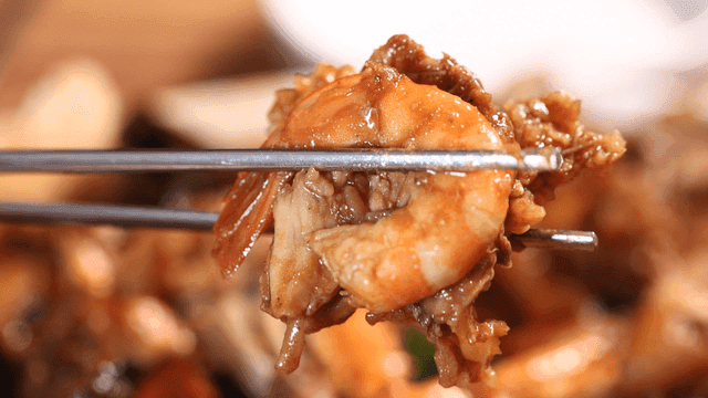 Cooked shrimp and braised chicken picked up with chopsticks
