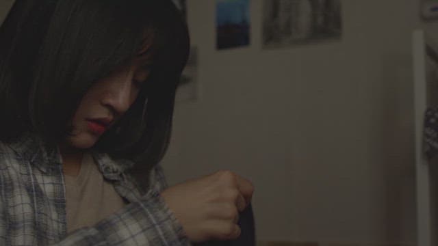 어두운 방에서 가방을 뒤져 물건을 찾는 여자