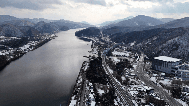 Snow-covered landscape with a river and mountains
