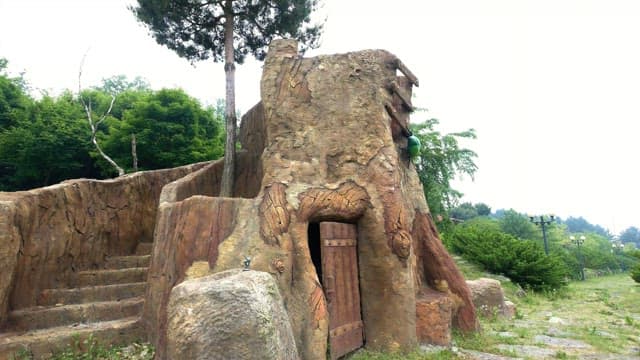 울창한 초록 공원 속의 문이 있는 조형물