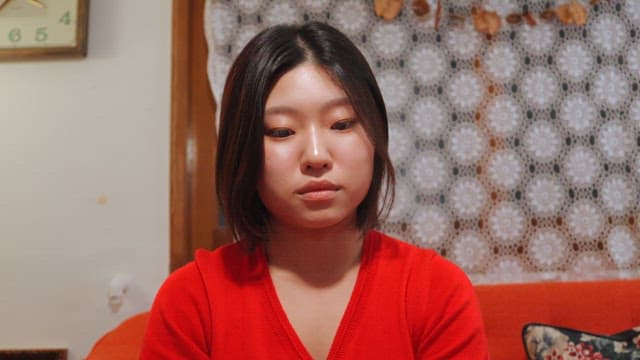 Woman in red sweater playing cards indoors