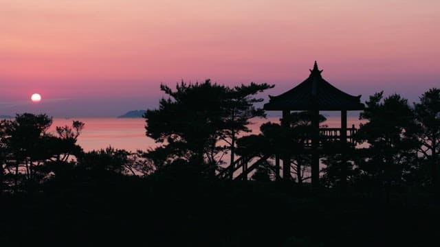 Red Sunset on the Sea Beyond a Traditional Pavilion