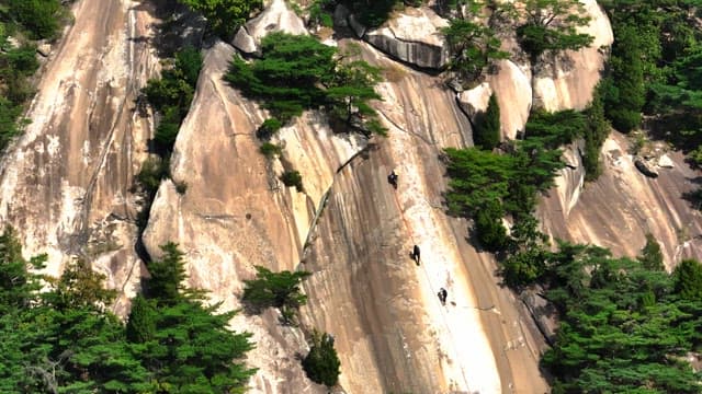 People climbing a steep rocky mountain