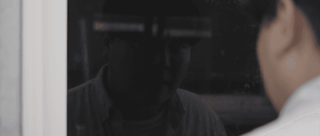 Person looking at their reflection in a window