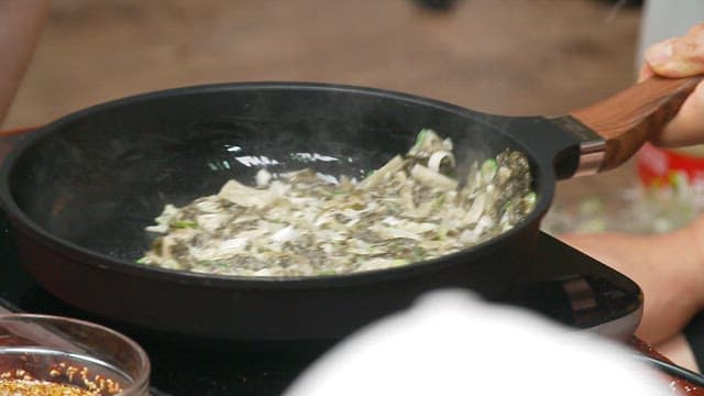 Dried radish greens pancake cooked in a heated frying pan