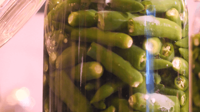 Green chili peppers in a glass jar