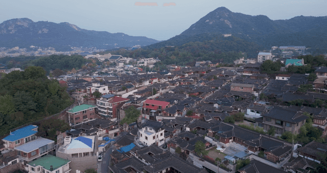 Traditional hanok village with distant mountain view