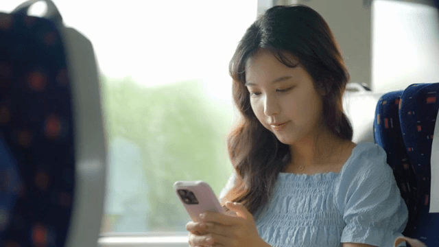 기차에서 스마트폰을 사용하는 여성