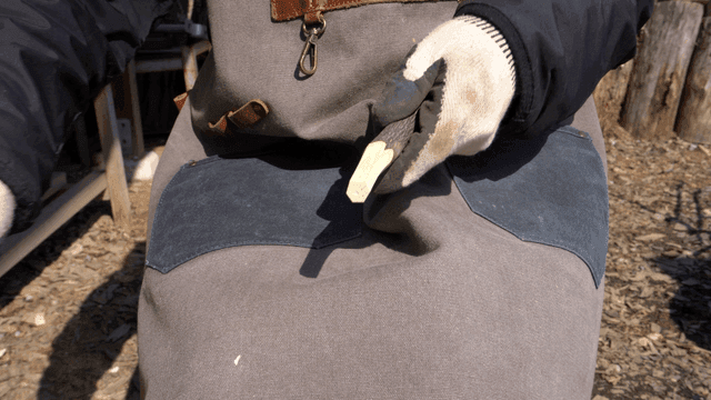 야외에서 칼로 나무를 날카롭게 다듬는 목공예가