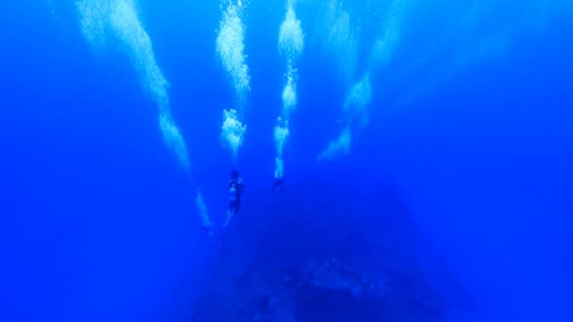 깊은 바다로 들어가는 스쿠버 다이버들