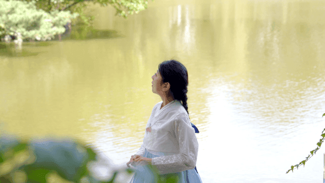 고요한 호수 옆 한복을 입은 여성