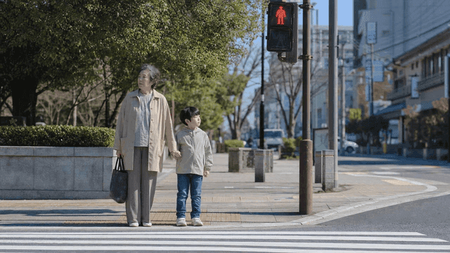 Elderly woman and child waiting at a crosswalk