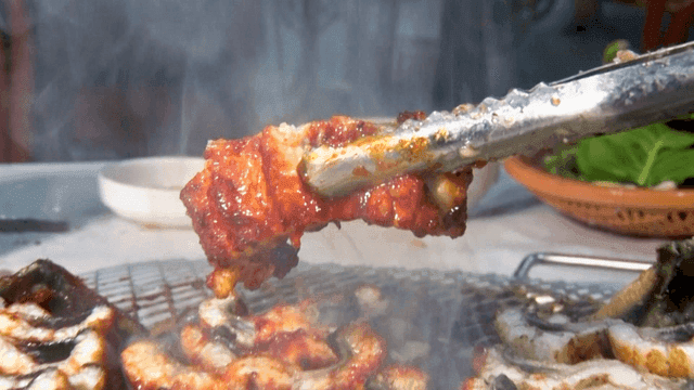 양념 장어 구이를 들어 올리는 집게