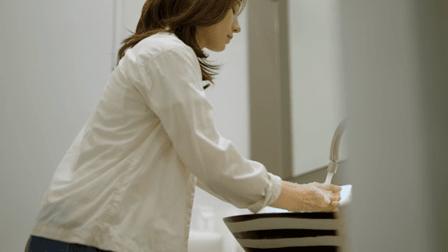 세면대에서 손을 씻는 여성