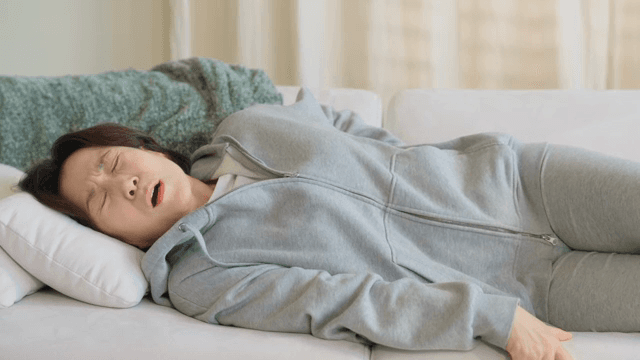 허리 통증으로 고통받는 소파에 누워있는 여성