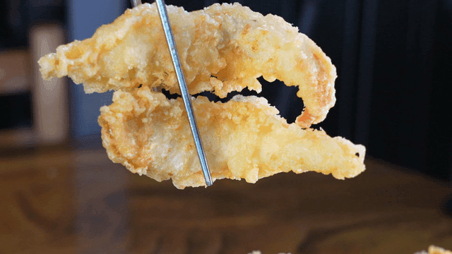 Golden fried food picked up with chopsticks