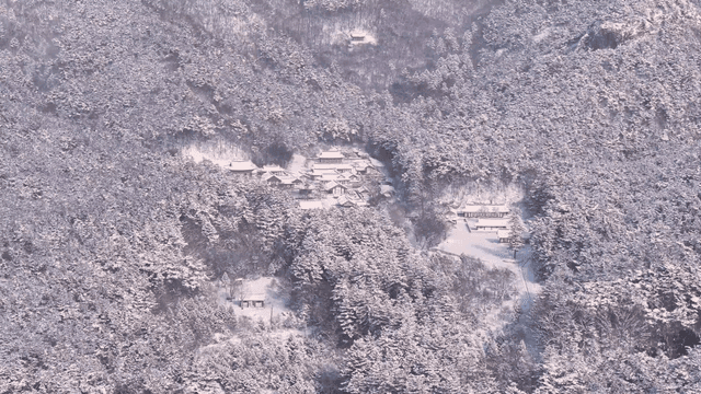 Snow-covered traditional Hanok village in forest