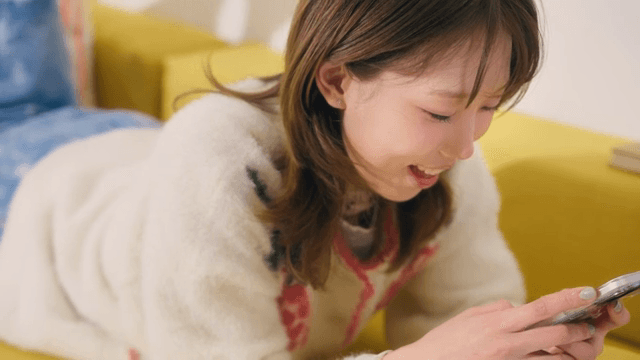 Woman smiling while using a smartphone