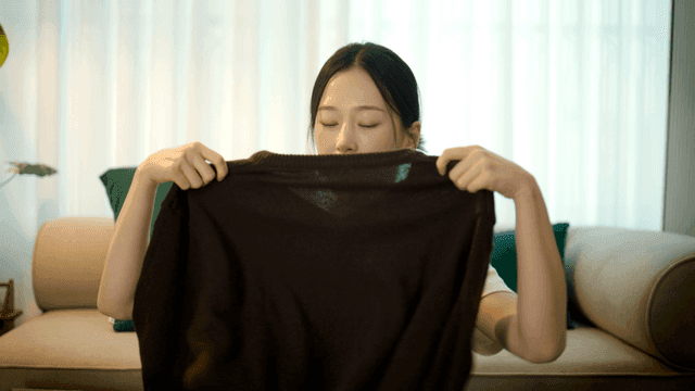 Woman trying on clothes on her body on sofa