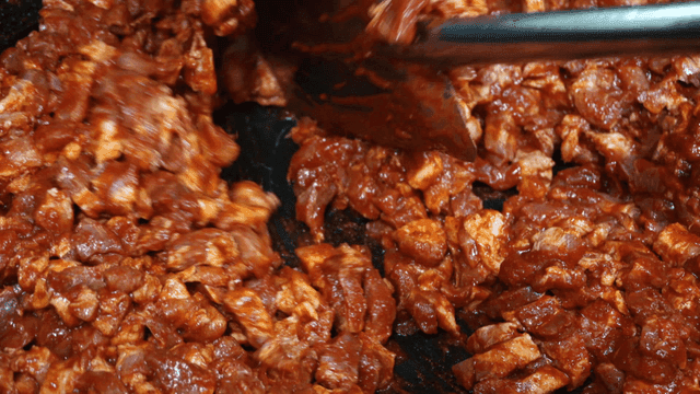 삽으로 섞여지는 양념된 돼지고기