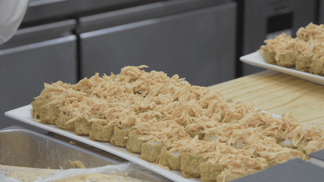Chef topping fried tofu sushi