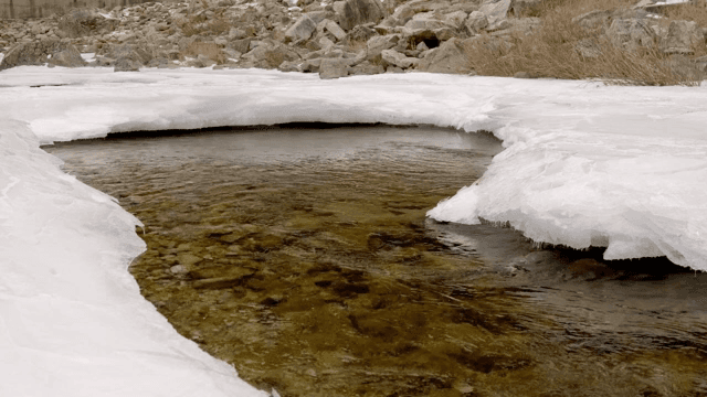 Flowing river with ice and rocks