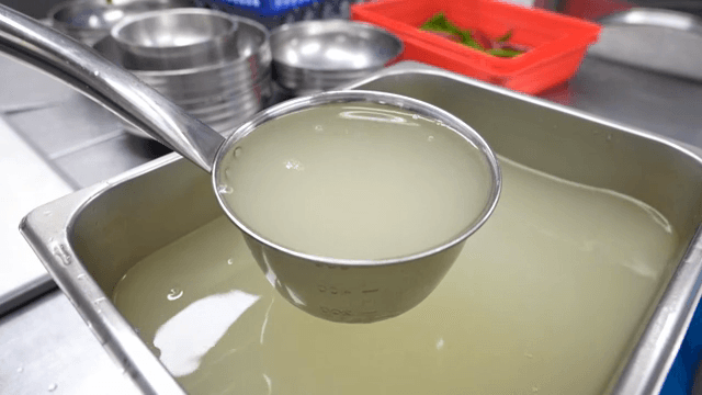 주방에서 국자로 육수를 뜨는 모습