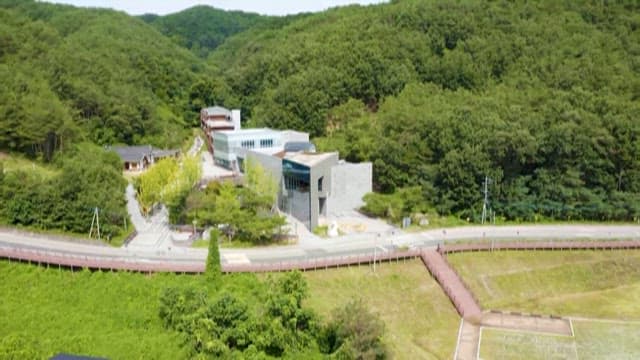 초록의 숲 속 현대적인 건물의 항공 촬영