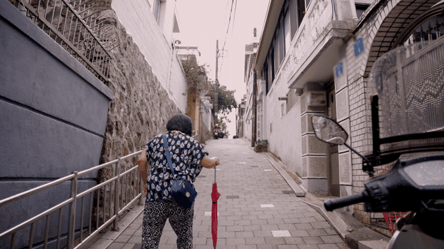 Elderly woman walking up a narrow alley
