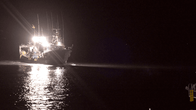 Fishing boats sailing with their lights on in night sea
