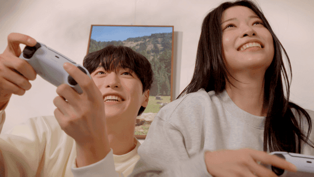 Couple playing video games playfully in living room