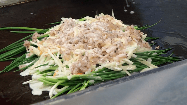 철판 위의 재료들에 붓는 반죽물