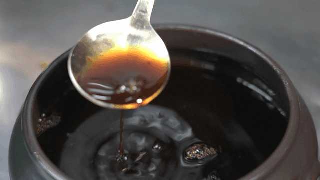Soy sauce being scooped from a jar