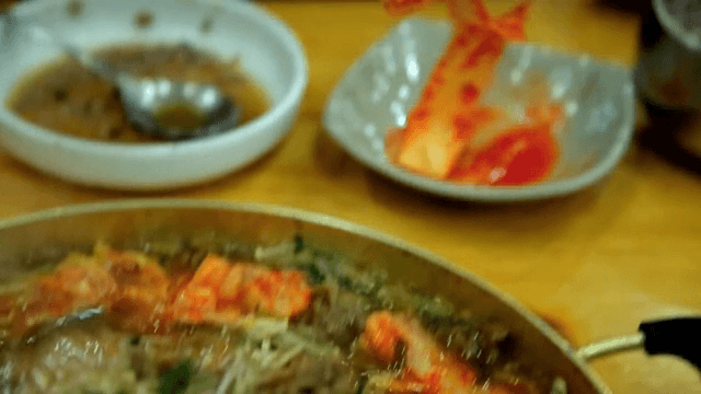 끓고있는 불고기 전골에 김치를 넣는 모습