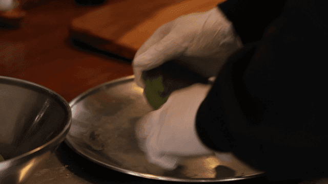 Hands kneading mugwort rice cake dough on metal tray