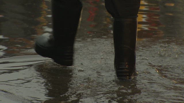 바닷물로 찰박이는 수산시장 바닥을 걷는 상인