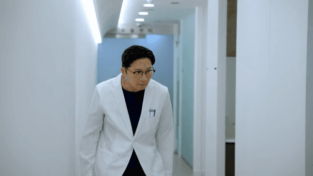 지친 모습으로 병원 복도를 걷는 의사