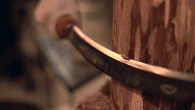 손 도구로 나무를 조각하는 모습