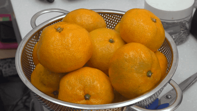 테이블 위 체에 담긴 신선한 귤