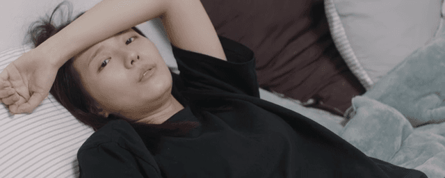 피곤한 상태로 침대에 누워 대화하는 여성