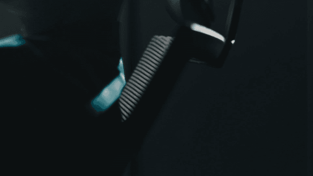 Person leaning back in chair in dark room