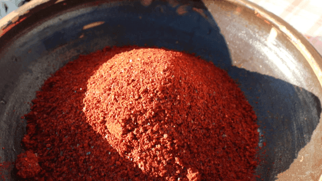 Red pepper powder being poured into a bowl