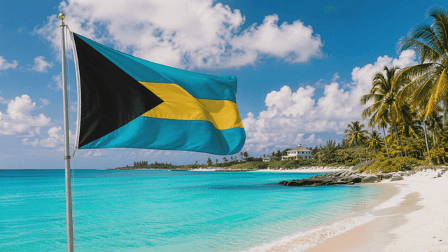Bahamian flag fluttering in wind and beach