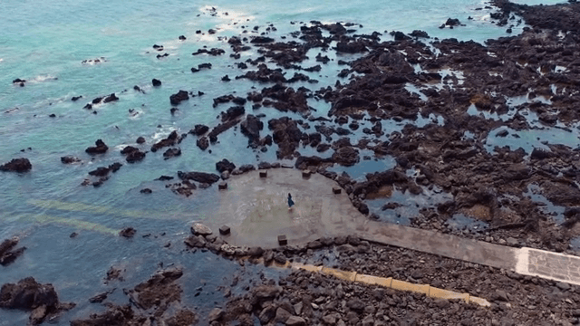 바위 해안에 서 있는 사람