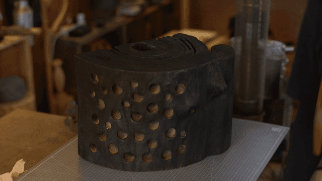 아늑한 작업장의 작업대 위 구멍이 난 나무 조각품