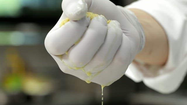 주방에서 장갑 낀 손으로 생강즙을 짜는 모습