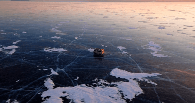 해질녘 얼어붙은 호수 위를 달리는 차량